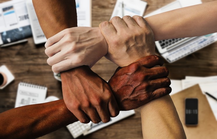 group of people grasping hands in unity